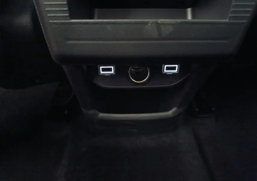 Prise USB arrière et prise 12V visibles sous la console centrale noire du Citroën C5 hybride 2026.