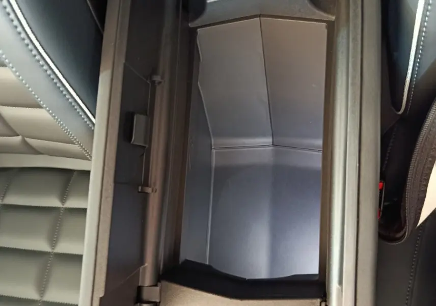 Vue rapprochée de la console centrale ouverte avec rangement intérieur noir dans un Citroën C5 Hybride 2026.