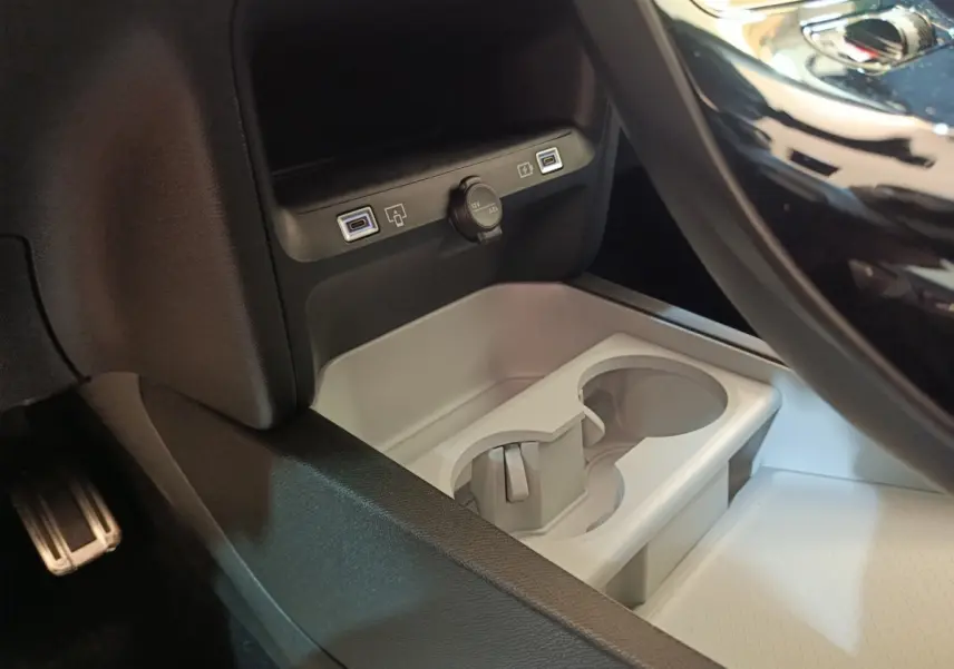 Gros plan sur la console centrale de la Citroën C5 Hybride 2026, montrant les ports USB et prise 12V, avec porte-gobelets gris.