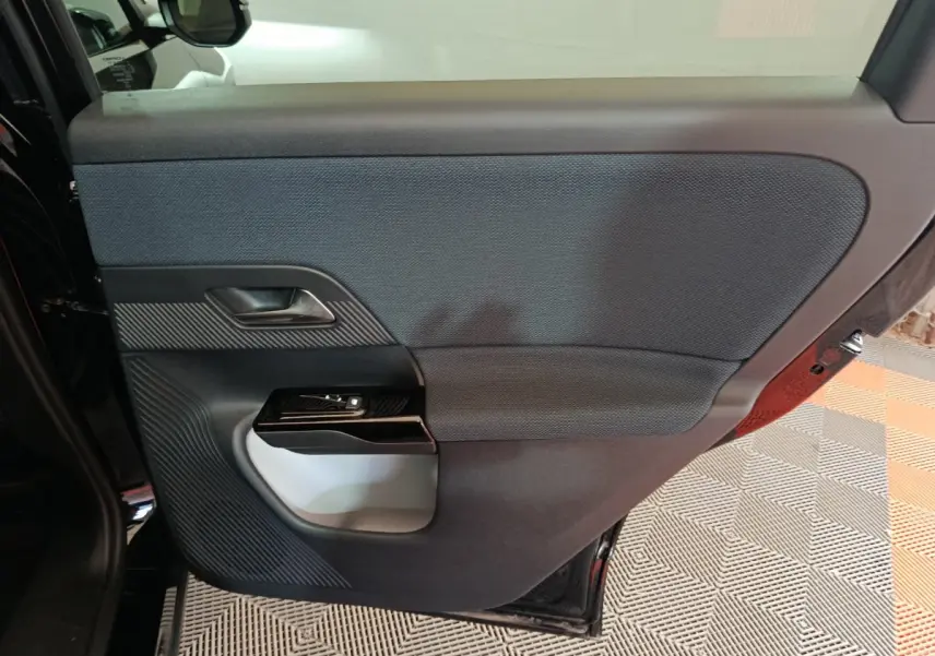 Vue intérieure de la porte arrière droite noire du Citroën C5 Hybride 2026 avec garniture textile et poignée intégrée.