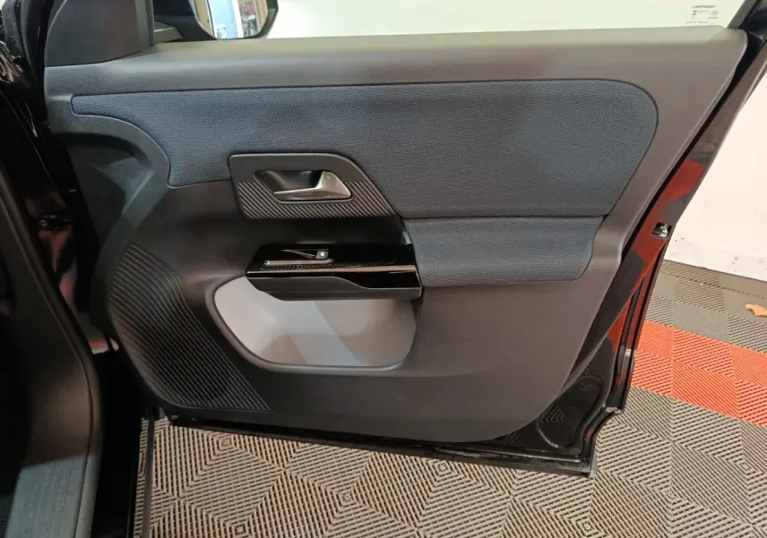 Vue rapprochée de la porte arrière droite noire du Citroën C5 Hybride 2026 avec habillage tissu et plastique.