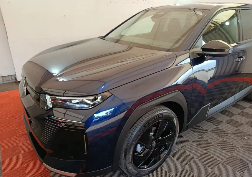 Vue 3/4 avant droit d'une Citroën C5 hybride bleu foncé avec jantes noires et phares LED distinctifs.