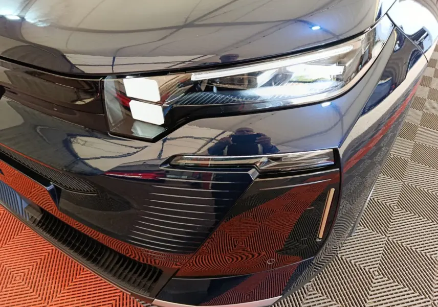 Gros plan sur l’avant droit bleu d’une Citroën C5 Hybride 2026 avec phares LED et détails de calandre moderne.