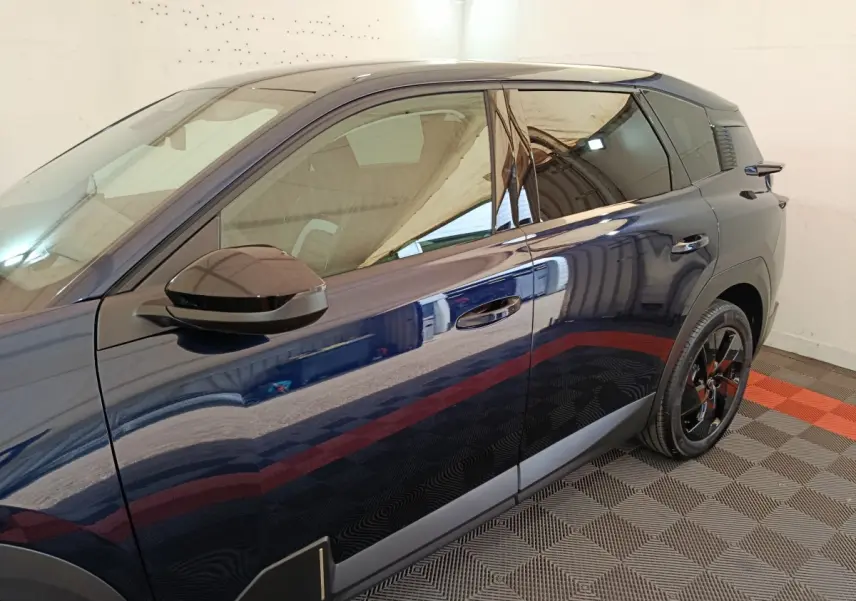 Vue latérale gauche d'une Citroën C5 hybride bleu foncé avec rétroviseur noir et jantes noires brillantes.