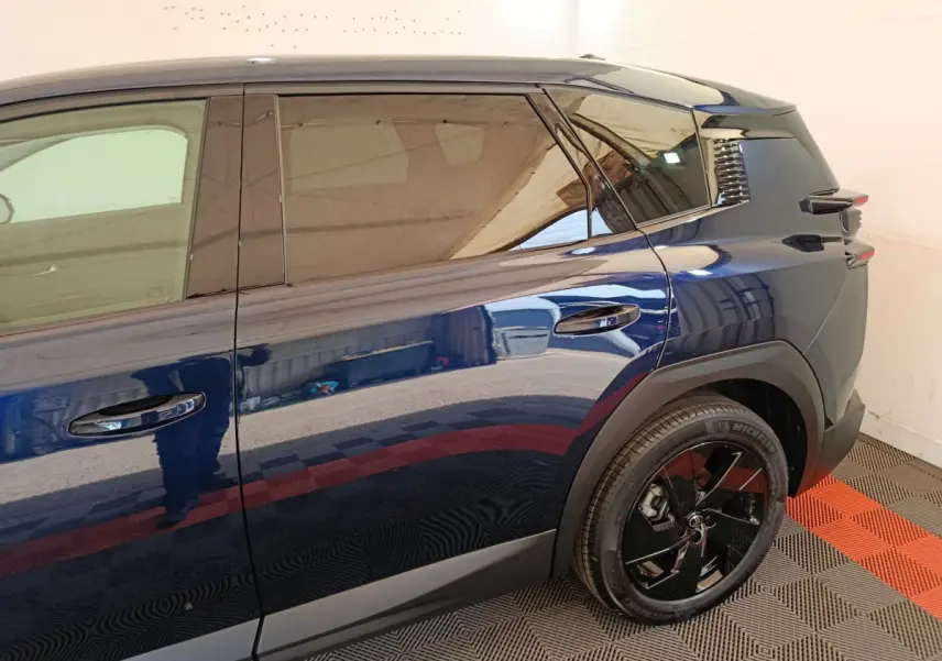 Vue latérale droite d'une Citroën C5 hybride bleu foncé avec jante noire et vitres teintées.
