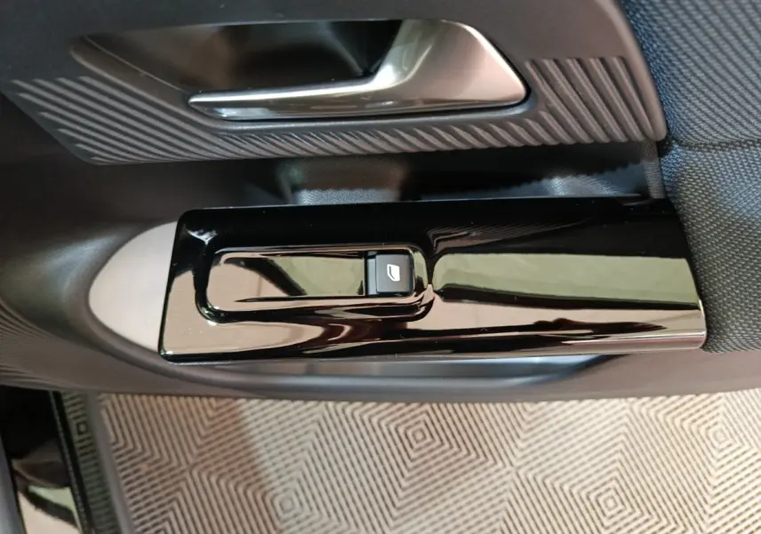 Gros plan sur la commande de lève-vitre noir brillant côté porte intérieure d'une Citroën C5 Hybride 2026.