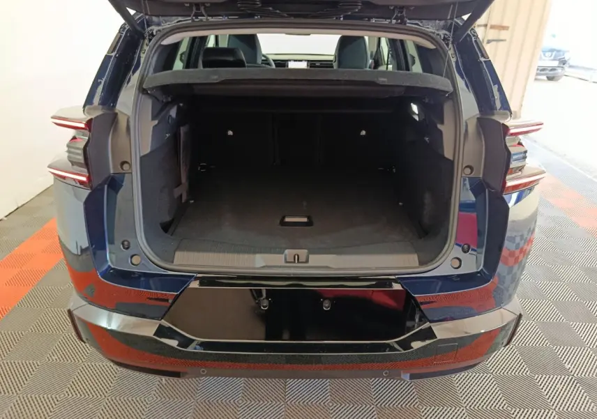 Coffre ouvert d'une Citroën C5 Hybride bleu vue arrière, avec feux arrière LED et seuil de coffre noir brillant.