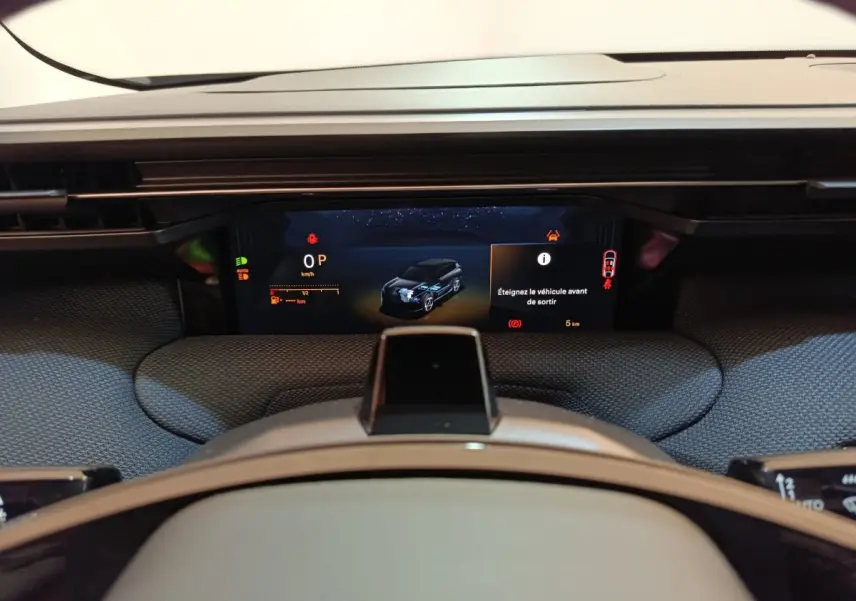 Vue rapprochée du combiné d'instruments numérique de la Citroën C5 Hybride 2026 avec affichage multifonctions et alertes visibles.
