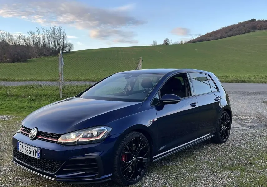 Volkswagen Golf VII GTI Performance bleu lapiz métal vue 3/4 avant droit avec jantes noires et calandre rouge