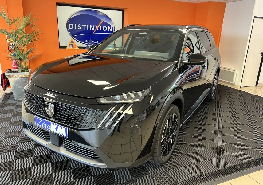 Vue 3/4 avant droite du Peugeot 5008 noir hybride 2025 avec calandre distinctive et jantes alliage 19 pouces.