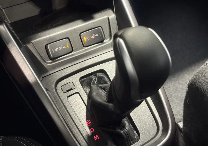 Le levier de vitesses automatique et les commandes de sièges chauffants du Suzuki Vitara beige 2023 vus de près.