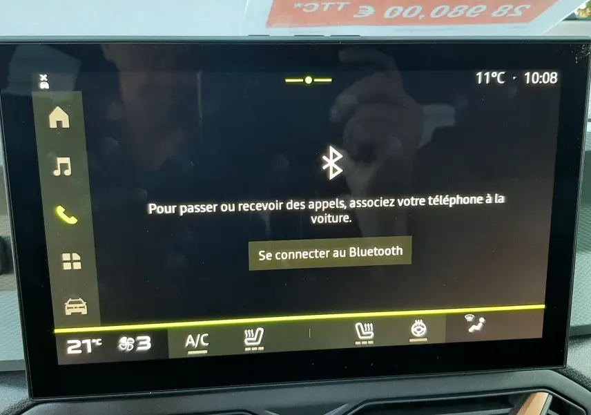 Écran tactile central du Dacia Duster 2025 en couleur Sandstone, affichant la connexion Bluetooth et commandes climatisation.