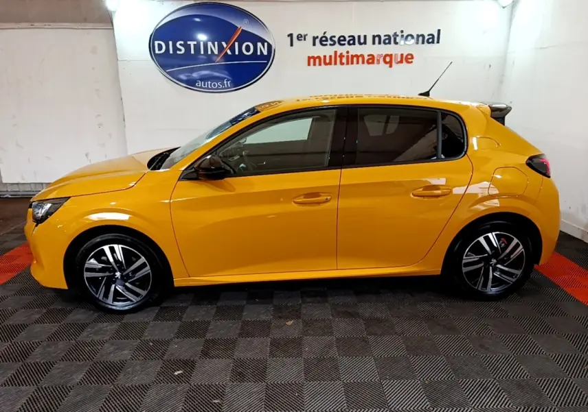 Peugeot 208 jaune vue de profil côté gauche, avec jantes alliage et vitres teintées dans un showroom.