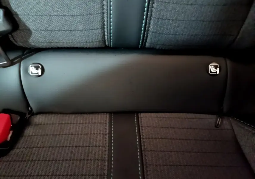 Gros plan sur la banquette arrière grise de la Peugeot 208 avec logos Isofix visibles de chaque côté.