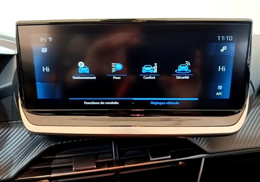Écran tactile central affichant les réglages de conduite dans l'habitacle d'une Peugeot 208 jaune 2023.