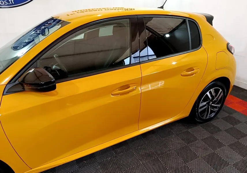 Profil latéral gauche d'une Peugeot 208 jaune vif, avec rétroviseur noir et jantes alliage modernes.