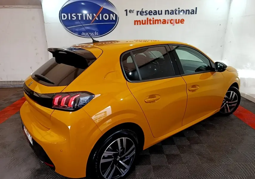 Vue 3/4 arrière droite d'une Peugeot 208 jaune 2023 avec feux LED et jantes alliage distinctives.