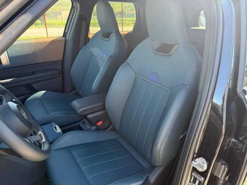 Vue intérieure côté gauche du MINI COUNTRYMAN 2024 Midnight Black II, sièges avant en cuir avec logo MINI brodé.