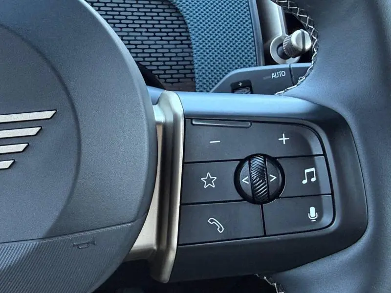 Gros plan sur la commande multifonction côté droit du volant noir de la MINI COUNTRYMAN 2024 Midnight Black II.