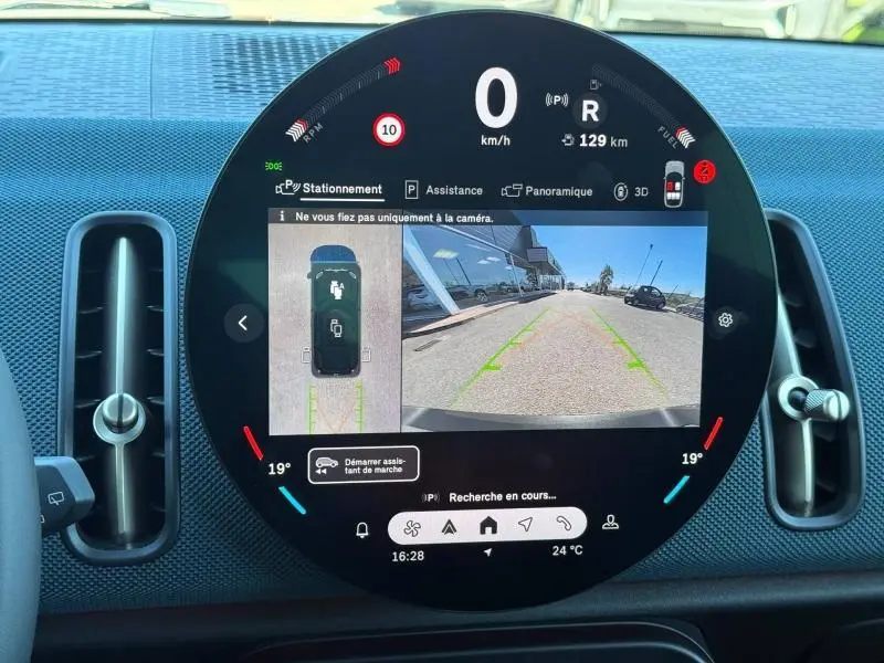 Affichage circulaire du tableau de bord du MINI Countryman 2024, montrant la caméra de recul et les aides au stationnement.