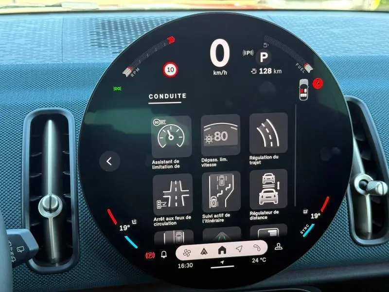 Affichage numérique central du tableau de bord du MINI COUNTRYMAN 2024, montrant les aides à la conduite et la température intérieure.