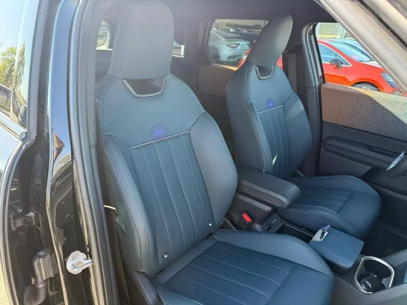 Vue intérieure côté gauche des sièges avant en cuir noir du MINI Countryman 2024 Midnight Black II, avec logo MINI brodé.