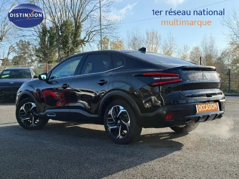Vue 3/4 arrière droite d'une Citroën C4 X noire 2024 avec feux arrière LED et jantes alliage distinctives.