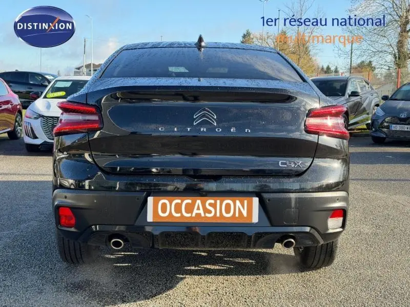 Vue arrière du Citroën C4 X noir 2024 avec feux LED et double sortie d’échappement, stationné en extérieur.