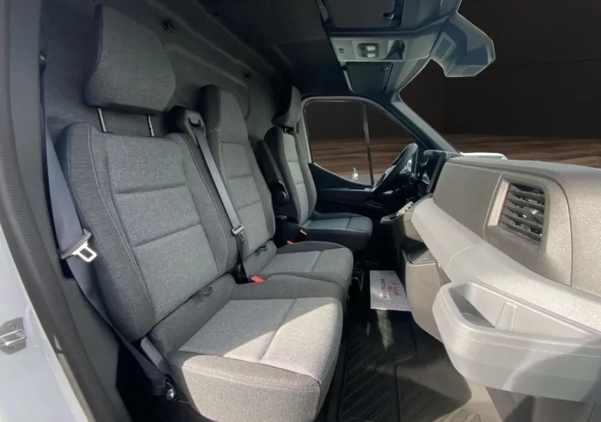 Vue intérieure côté conducteur du Renault Master 2025, montrant les sièges gris et le tableau de bord clair.