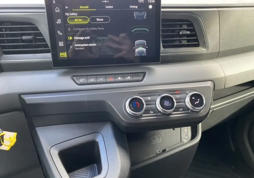 Vue intérieure du tableau de bord du Renault Master blanc 2025 avec écran tactile et commandes de climatisation.