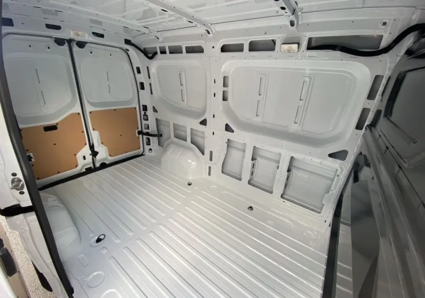 Intérieur du compartiment de chargement blanc du Renault Master FG L2H2, vue depuis l'arrière vers l'avant avec portes ouvertes.