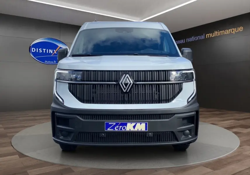 Vue frontale d’un Renault Master blanc 2025 avec calandre noire verticale et phares LED intégrés, plaque Zéro KM visible.