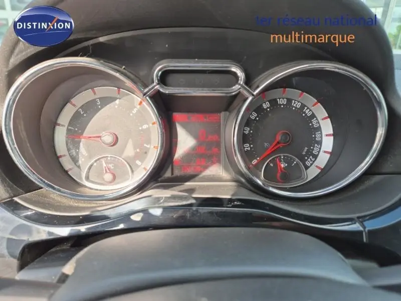 Vue rapprochée du tableau de bord de l'Opel Adam 2017 montrant les compteurs ronds avec éclairage rouge et chrome.