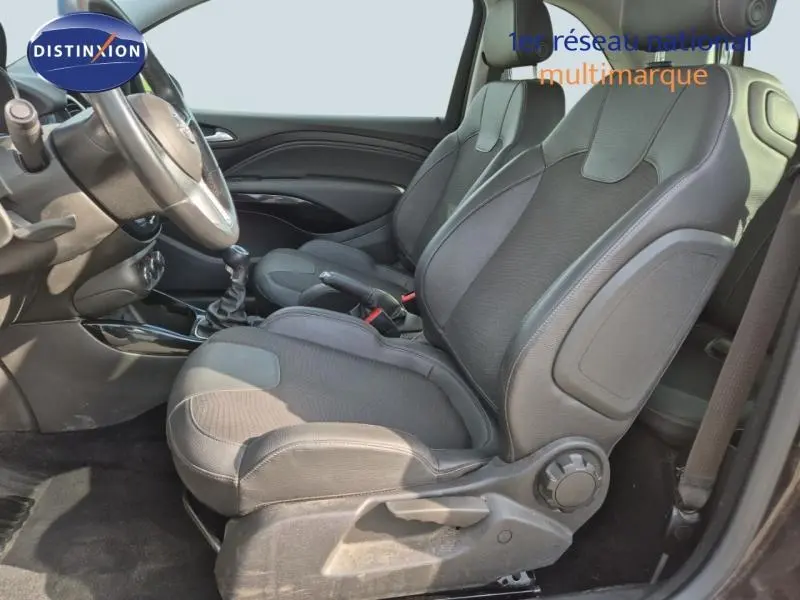 Vue intérieure côté gauche de l'Opel Adam 2017, sièges avant en sellerie mixte noire avec volant cuir multifonction.