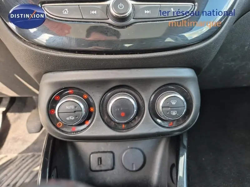 Gros plan sur les commandes de climatisation et les prises USB d'une Opel Adam marron de 2017.