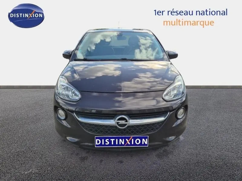 Vue avant d'une Opel Adam marron avec calandre chromée et phares arrondis, sur fond neutre avec logo Distinxion.