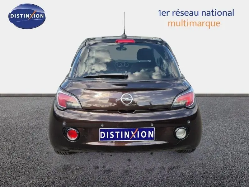 Vue arrière d'une Opel Adam marron 2017 avec feux arrière LED et plaque Distinxion visible sur fond neutre.