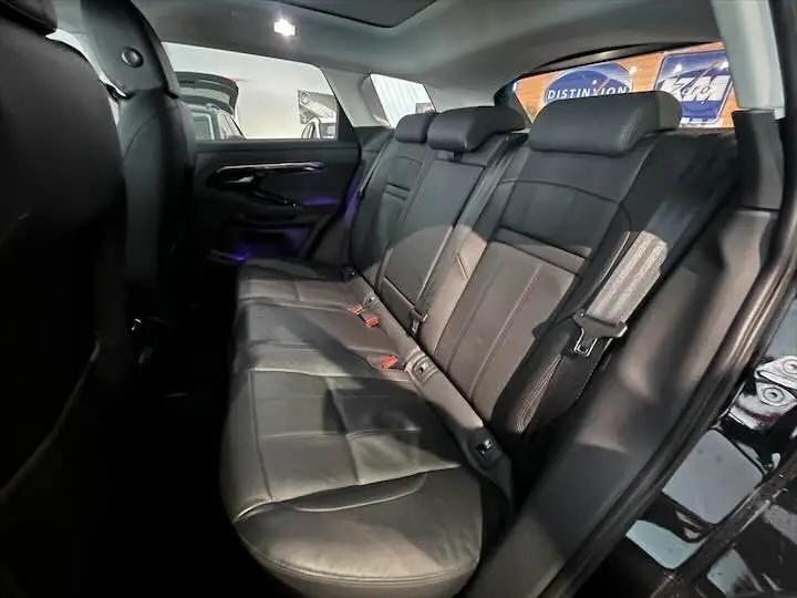 Vue intérieure côté droit des sièges arrière en cuir noir du Range Rover Evoque II 2020 dans un showroom.
