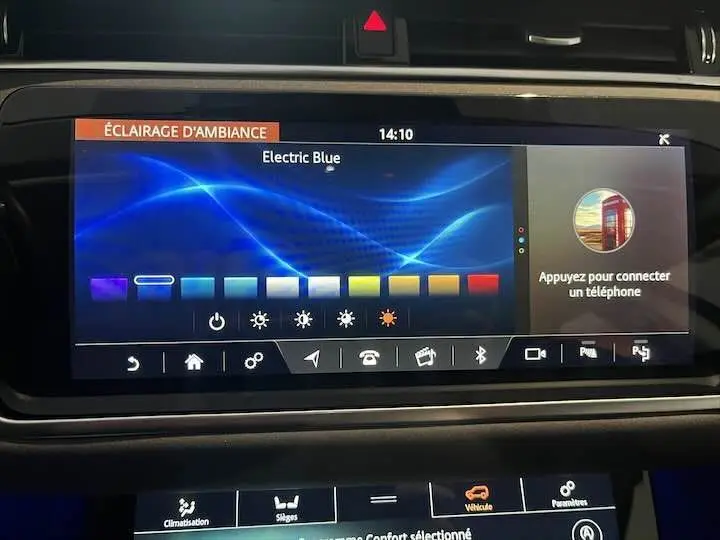 Écran tactile du tableau de bord du Range Rover Evoque noir, affichant le réglage d’éclairage d’ambiance en bleu électrique.