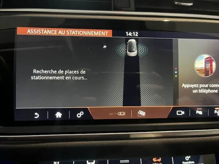 Écran central du Range Rover Evoque noir Santorini montrant l'assistance au stationnement en cours à 14h12.