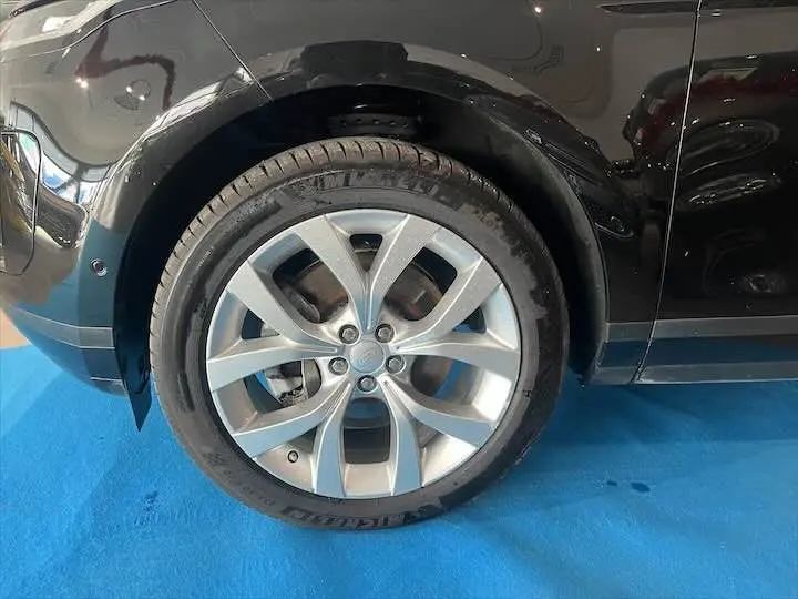 Gros plan sur la roue avant gauche argentée du Range Rover Evoque noir Santorini, avec pneu Michelin visible.