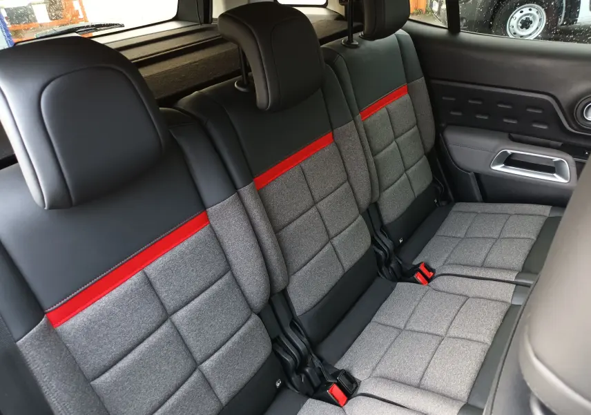 Vue rapprochée des sièges arrière gris et noirs avec bande rouge du Citroën C5 Aircross 2020 côté droit.