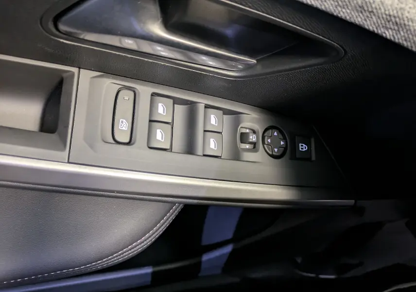 Gros plan sur les commandes de lève-vitres et rétroviseurs côté conducteur du Peugeot 5008 blanc Okenite.
