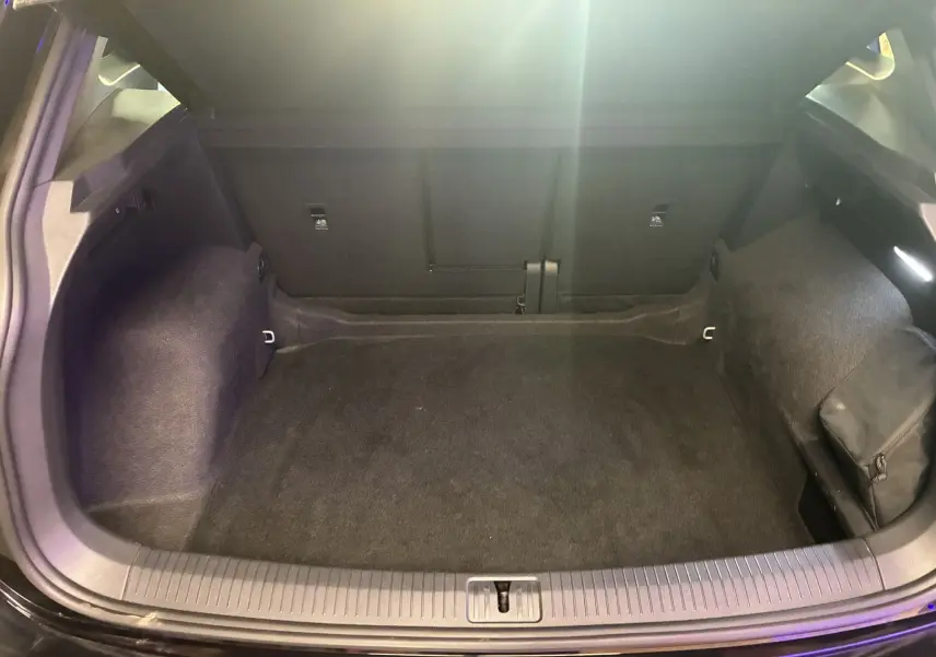 Coffre ouvert noir du Volkswagen Tiguan 2.0 TDI 150 DSG7 R-LINE Phase 2, montrant un espace de chargement propre et spacieux.