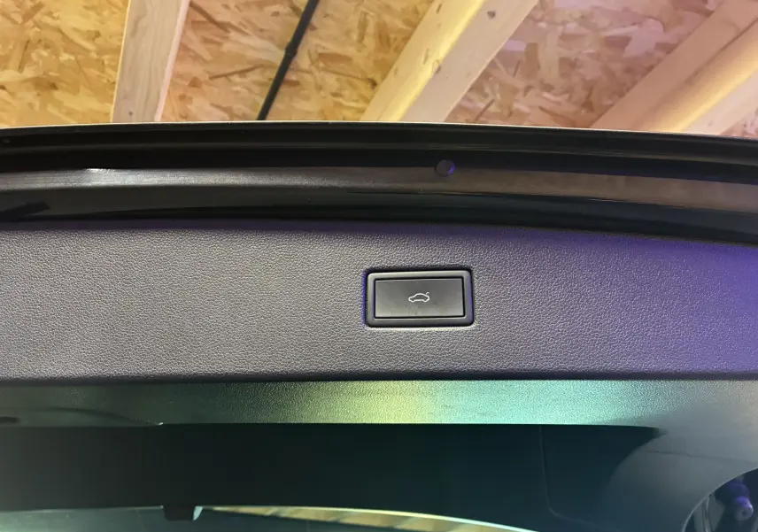 Bouton d'ouverture électrique du hayon sur la partie intérieure du coffre d'un Volkswagen Tiguan noir 2022.