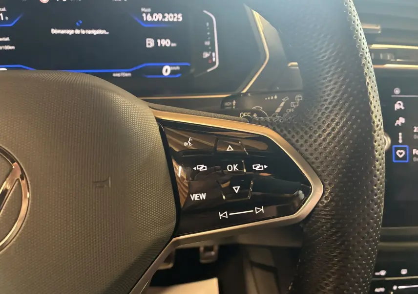 Gros plan sur les commandes multifonctions à droite du volant cuir perforé du Volkswagen Tiguan noir 2022.