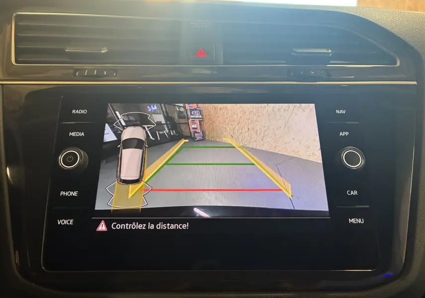 Écran tactile intérieur du Volkswagen Tiguan 2.0 TDI noir montrant la caméra de recul avec guidage de trajectoire.