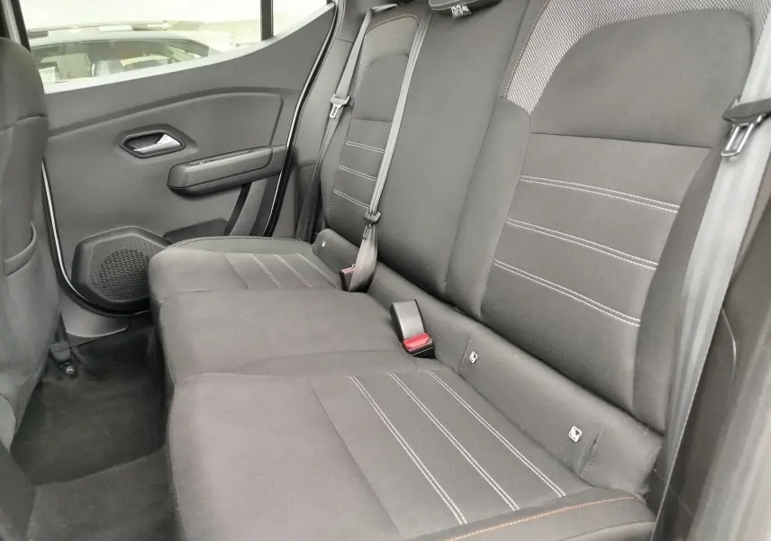 Vue intérieure côté droit des sièges arrière en tissu gris foncé avec surpiqûres blanches d'une Dacia Sandero Stepway 2021.