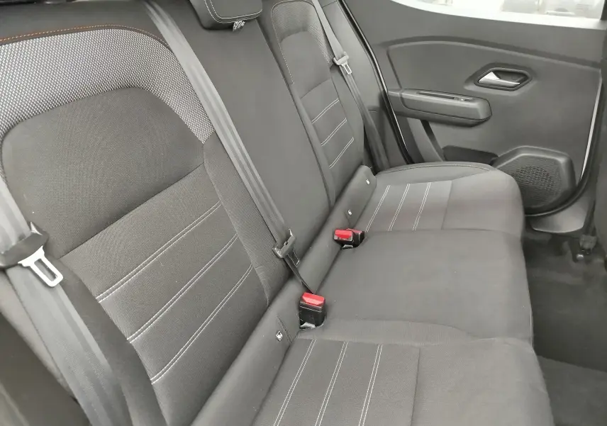 Vue latérale droite de la banquette arrière en tissu gris foncé de la Dacia Sandero Stepway 2021 blanc glacier.