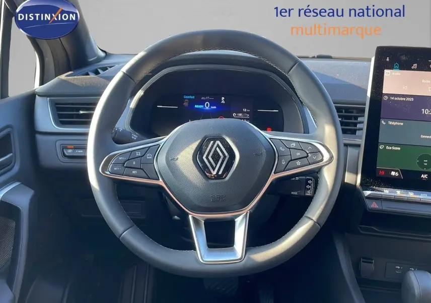 Vue intérieure centrée sur le volant Renault du Captur E-Tech gris rafale, avec tableau de bord digital et écran tactile.